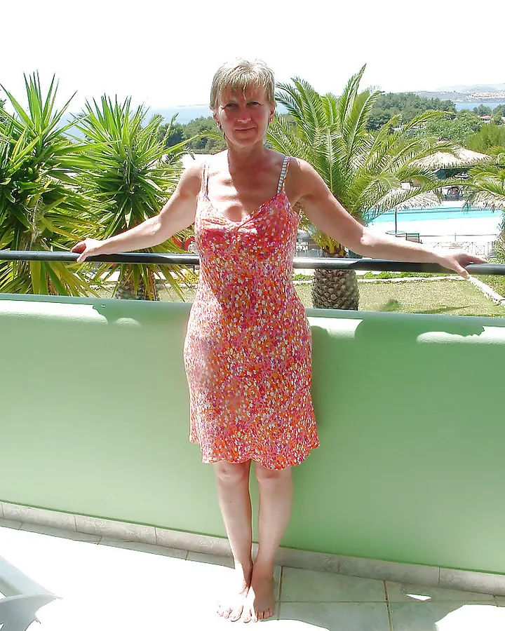 Femme en haut noir, posant sur un canapé, souriante