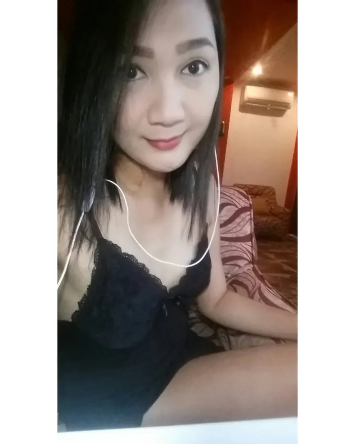 Jeune femme asiatique en lingerie noire, tenant des écouteurs